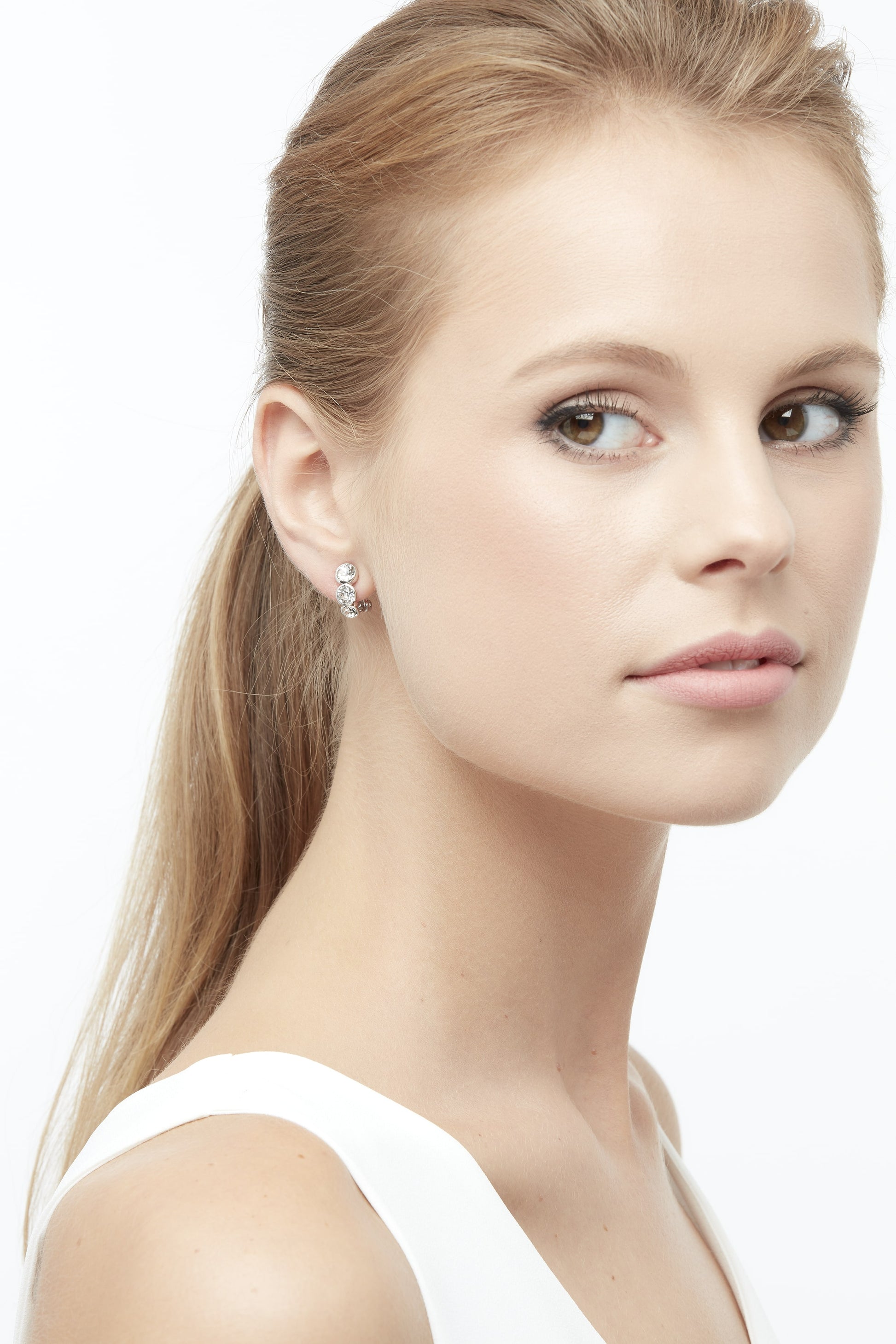 A silver and crystal curved clip on earring on a model