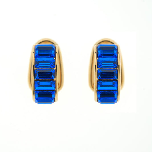 Gold hoop earrings with blue gemstones on a white background