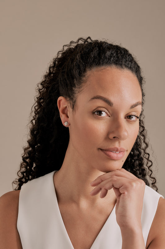 A model wearing silver crystal pave clip on earrings