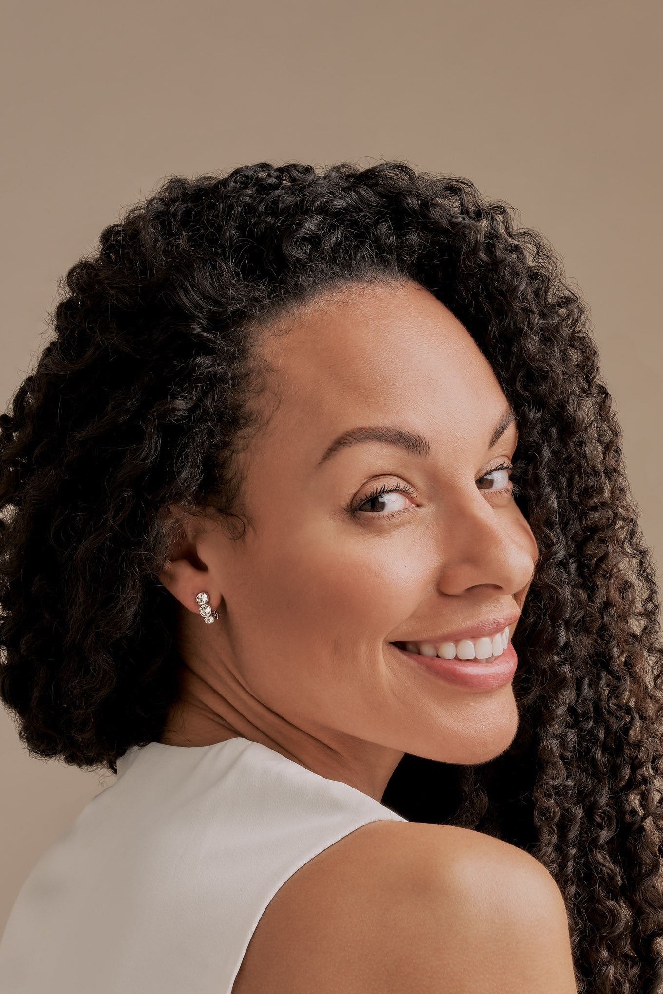 A pair of platinum and crystal earrings on a model