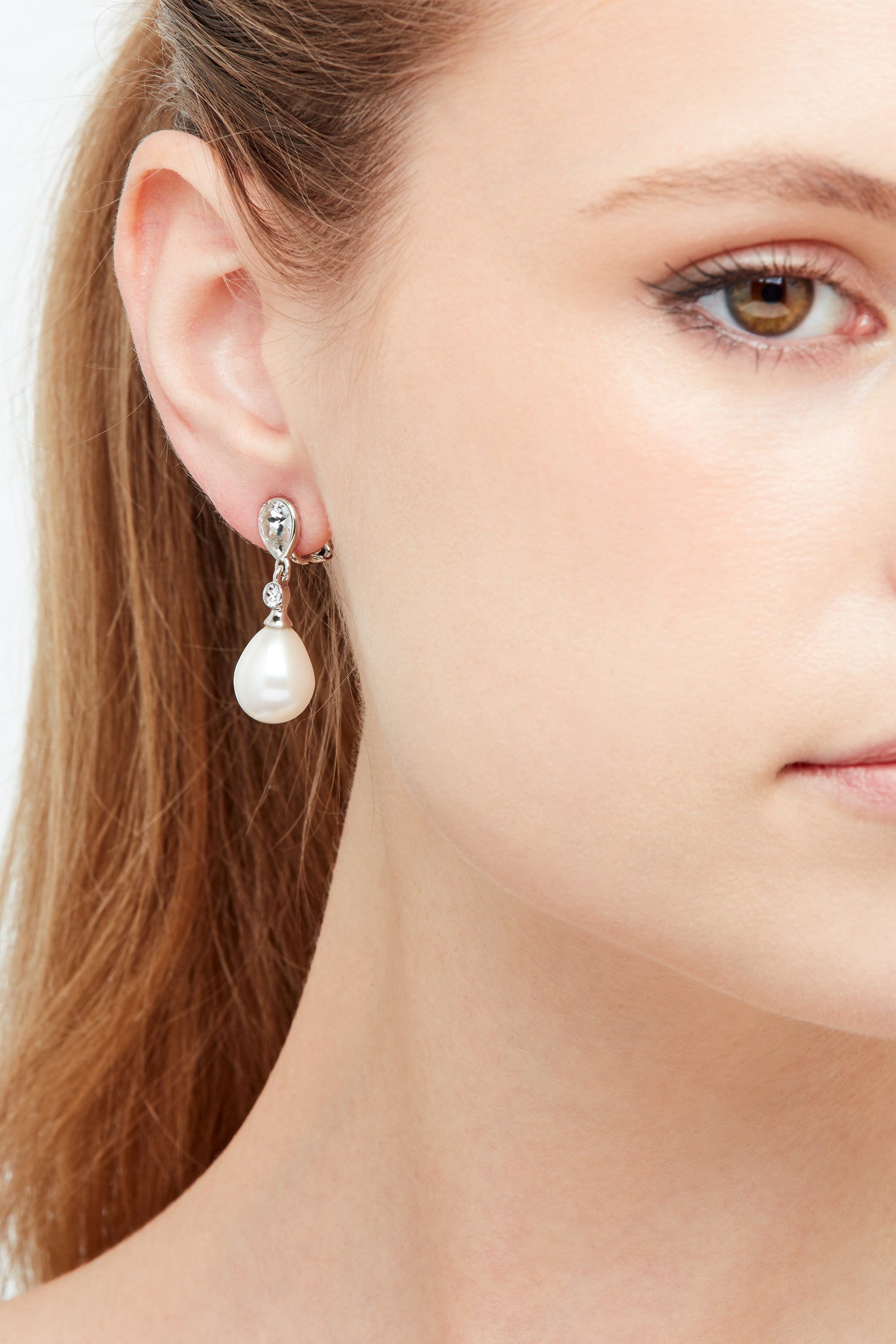 A close up model shot of platinum crystal pearl earrings