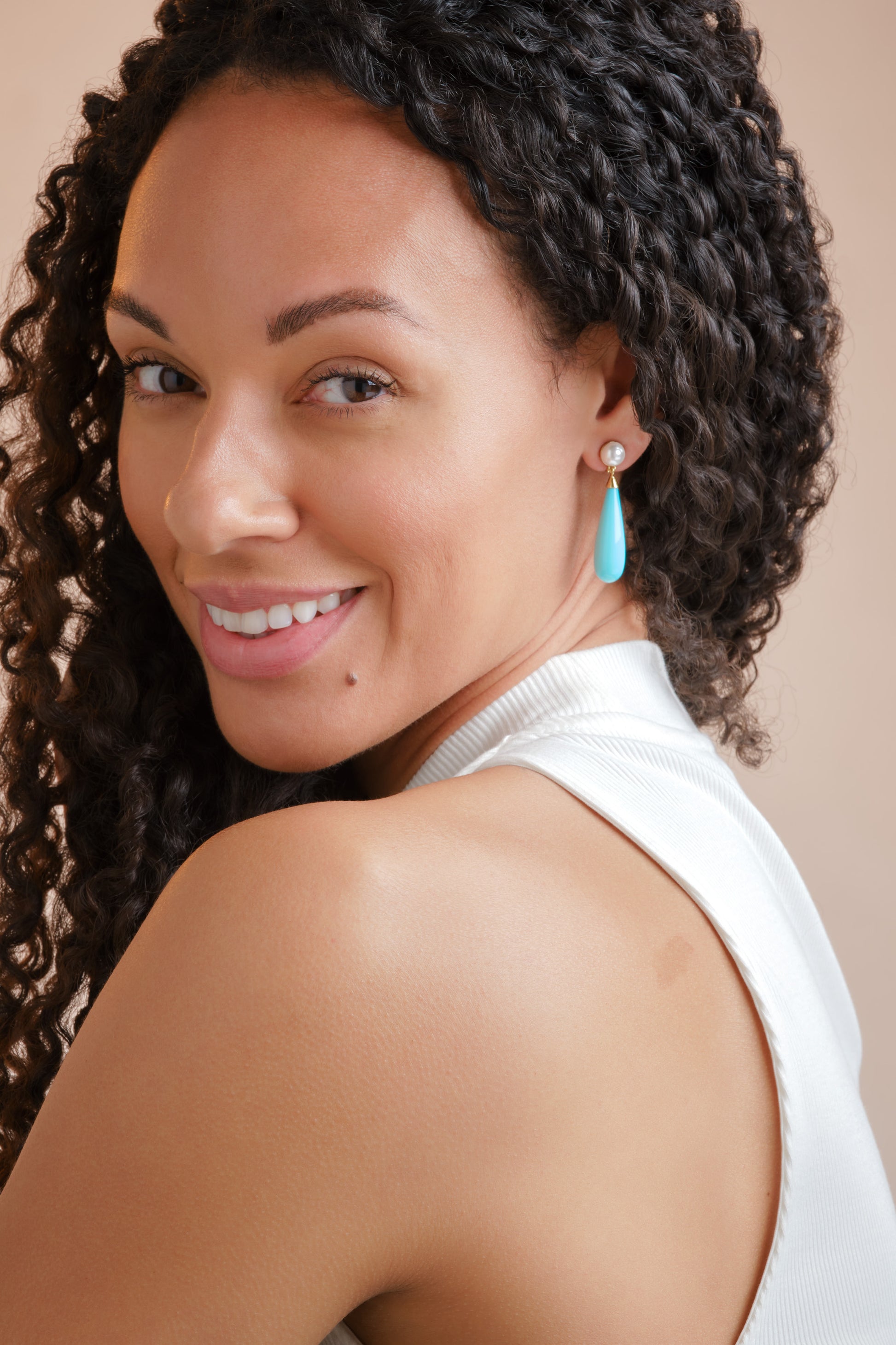 A model in turquoise drop clip on earrings