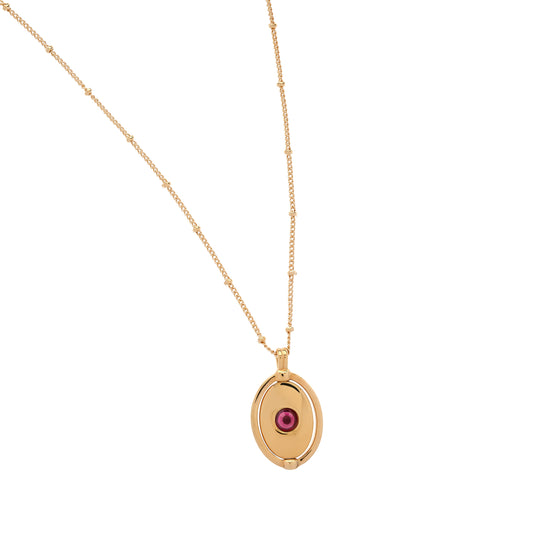 Gold necklace with a red gemstone pendant on a white background